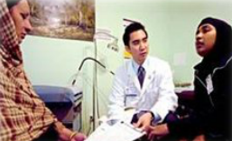 A doctor speaking to his patient through an interpreter.